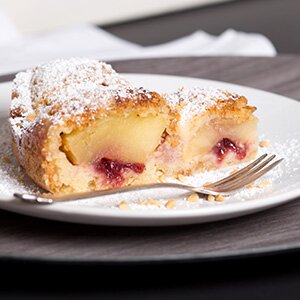 Saftiger Apfelkuchen mit Schlagsahne, Preiselbeeren und Granola
