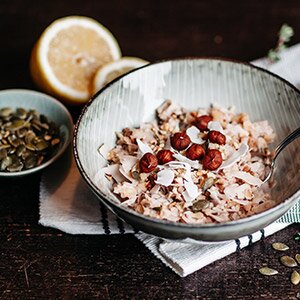 Frühstücksbrei mit Kokosmilch, Nüssen, Kernen und Banane
